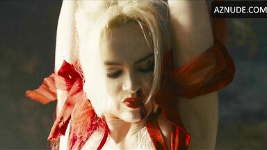 Margot flexes her leg to free herself