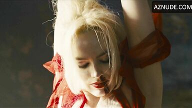 Margot flexes her leg to free herself