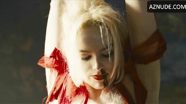 Margot flexes her leg to free herself