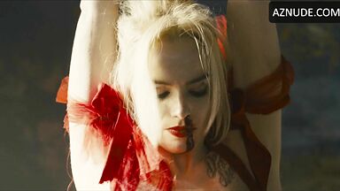 Margot flexes her leg to free herself