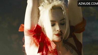 Margot flexes her leg to free herself