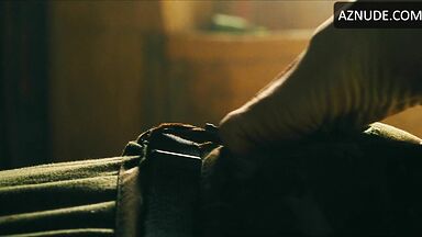 Margot flexes her leg to free herself