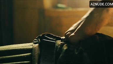 Margot flexes her leg to free herself