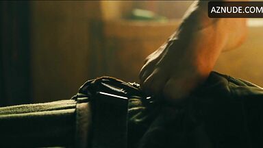 Margot flexes her leg to free herself