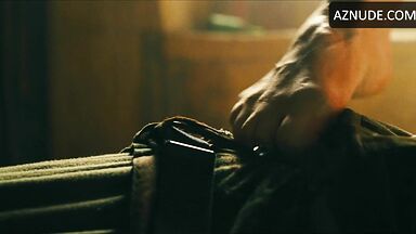 Margot flexes her leg to free herself