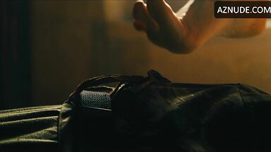 Margot flexes her leg to free herself