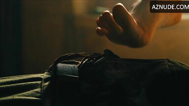 Margot flexes her leg to free herself