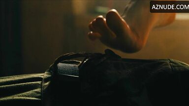 Margot flexes her leg to free herself