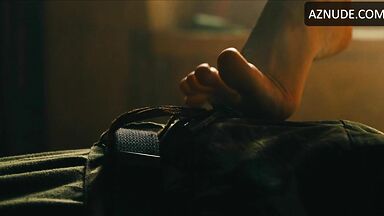 Margot flexes her leg to free herself