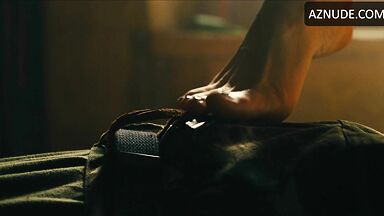 Margot flexes her leg to free herself