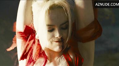 Margot flexes her leg to free herself